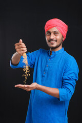 Naklejka premium Indian farmer holding wheat in his hand and smiling.