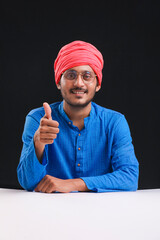 Fototapeta premium Young indian farmer giving expression on dark background.