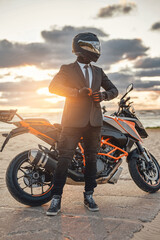 Naklejka premium Active businessman with modern sports motorbike on beach