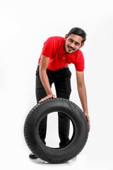 Obraz na płótnie Canvas Handsome young male mechanic with new tires isolated on white background.