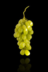 Bunch of white grapes on a black background with reflection