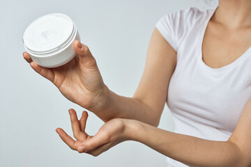 woman in white t-shirt holds cream in hands skin care moisturizing health hygiene