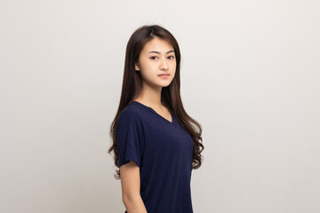 Obraz premium Beautiful young asian woman standing on isolated white background. Thai Teenage girl around 20 looking at camera.