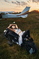 Young dreamy woman lying on the motorbike