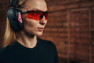 Serene pretty lady in shooting earmuffs staring into the distance © Svitlana