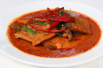 Easy homemade food, Salmon cooked in Thai Panang curry sauce with chili pepper and sliced bergamot leaf. Curry food recipe in Thai style.