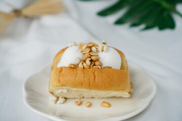 Coconut ice cream with bread. A soft bread topped with two scoop of coconut sorbet ice cream and peanut. A famous Thailand street food.