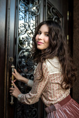 Naklejka na ściany i meble portrait of young lady wear a fashion cloth posing near old texture doors