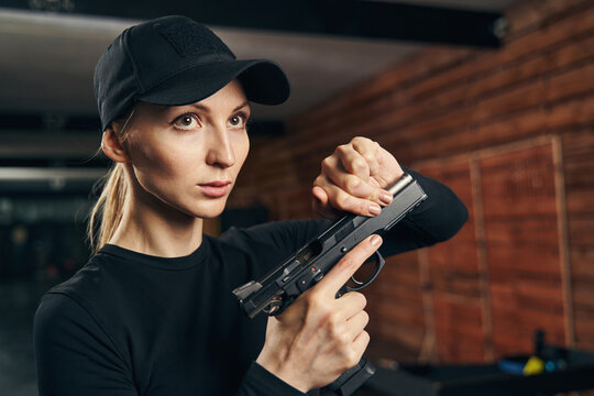 Beautiful Caucasian blonde lady reloading her gun