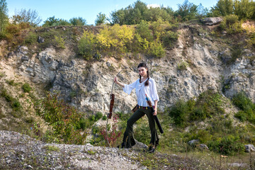  indian woman poses in a nature surrounding with arrow and bow