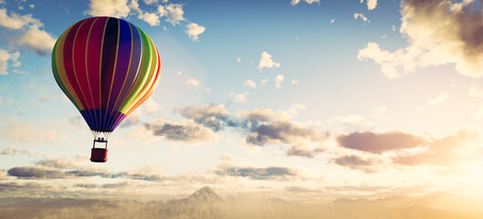 Fototapeta premium Hot air balloon flying above clouds at sunset