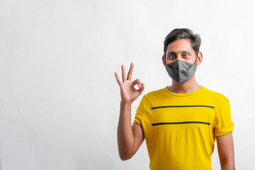 Naklejka premium young indian man wearing mask for protection against virus.