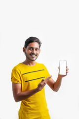 young indian man showing Smartphone over white background.