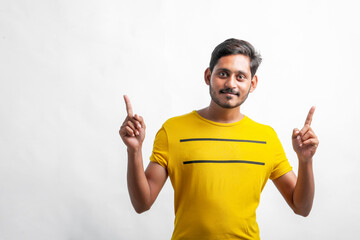 Fototapeta premium Young indian man showing direction with hand over white background.