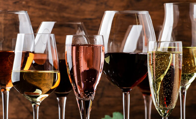 Wine tasting. Red, white, rose and champagne - still and sparkling wines sin glasses on vintage wooden table background