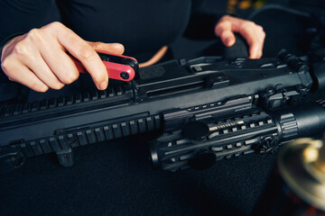 Experienced Caucasian military woman assembling the assault rifle