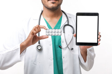 Young indian doctor showing tablet screen on white background.