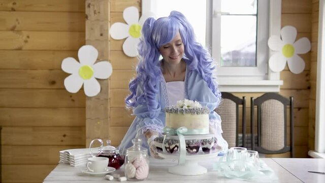 Beautiful woman with blue wig in a dress in the house.