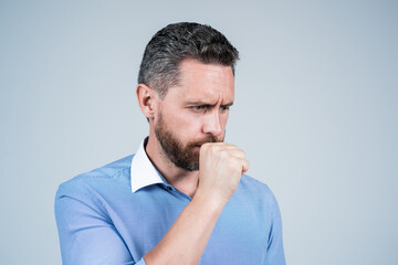 Middle-aged man manager coughing of respiratory infection blue background, cough