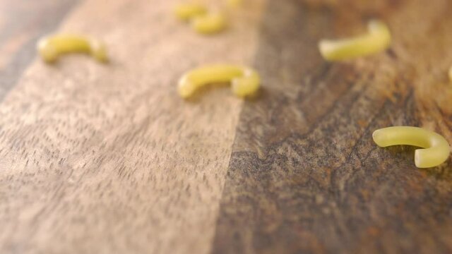 Raw traditional gobbetti pasta fall on a wooden board. Old european Italian cuisine concept. Slow motion. Macro shot