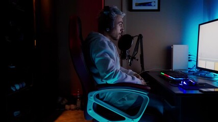 Young man sitting at computer playing video game