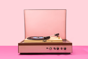 Gramophone record player from sixties. Turntable for single vinyl with pink bottom with light pink...
