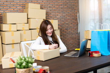 Fototapeta na wymiar Small business startup entrepreneur SME or freelance woman working with boxes at home or office. handling delivery packages. Online marketing packaging box and delivery. Business Logistic and Delivery