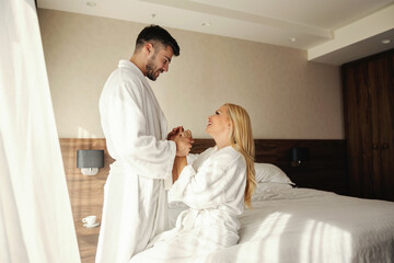 Obraz na płótnie Canvas Romantic weekend without children Waking up with gentle touches and kisses in a hotel room Beautiful couple in a luxury spa hotel fills with positive energy after a stressful week Comfort in bathrobes