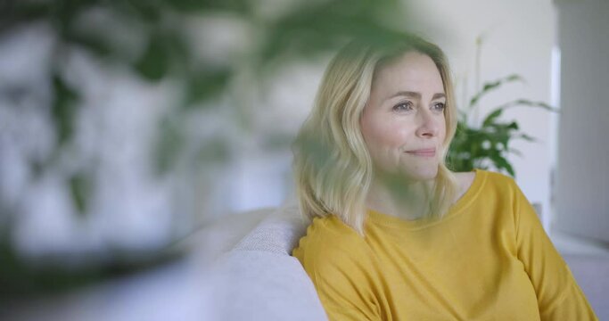 Cofident woman sitting on couch, smiling