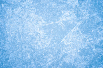 Openwork pattern of blue ice with a layer of white frost, snowflakes and natural illumination. Background