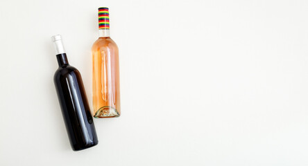 Rose wine bottle and red wine bottle . Minimalistic wine composition top view on white background copy space. Two bottles of Wine brand mockup. Long web banner Flat lay.