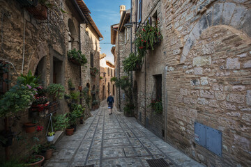 Fototapeta na wymiar A young man walk along the beautiful streets of Spello, Umbria