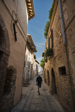 Fototapeta A young man walk along the beautiful streets of Spello, Umbria