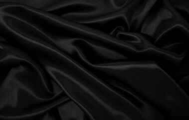 Smooth elegant black silk or satin luxury cloth texture as abstract background. Luxurious background design