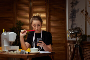 Beautiful young seamstress working on sewing machine