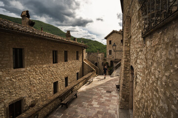 Fototapeta na wymiar a young man walking into the little street of Vallo di nera, Umbria