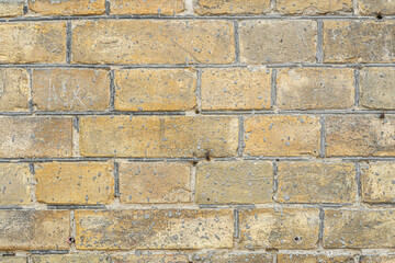 Close-up of an old brick wall of the late 19th century made of light brown bricks.