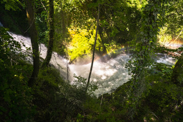 sun shining through trees into waterfalls of Marmore