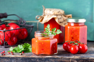 Homemade sauce made from ripe red tomatoes in glass jars.