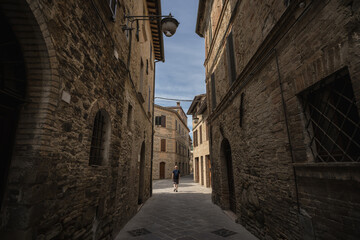 A young man is walking into a beautiful old town
