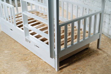 The image of the child's bed, in the frame of the bed legs and drawers.