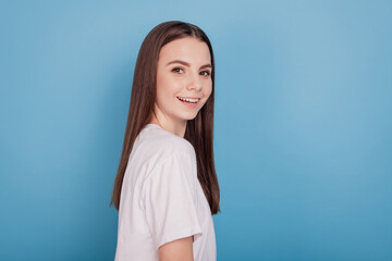 Portrait of adorable lovely positive teen lady look camera beaming smile on blue background