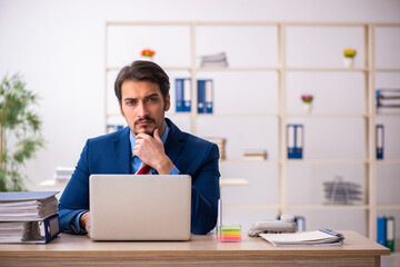 Young male employee sitting at workplace