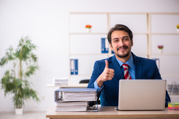 Young male employee sitting at workplace