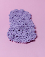 Knitted tablecloth for glass base is made of wool yarn made by hand by hand. Isolated purple background. Knitted tablecloth. Unique design with high knitting skills. Focus blur. Tablecloth Mockup.