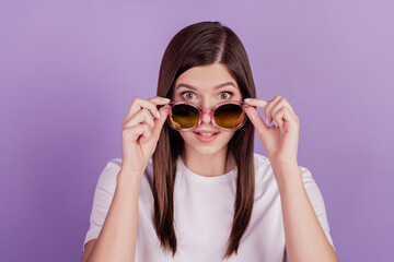 Photo of funny girl touch sunglasses isolated on violet background