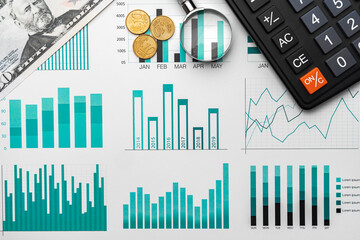 Business graphs paper and calculator on table