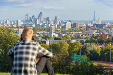 View of London city skyline from Parliament Hill in Hampstead Heath through a tourist  - obrazy, fototapety, plakaty
