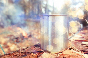 iron mug with hot tea on a camping trip active lifestyle autumn yellow park