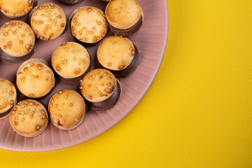 ピンクの皿に並べられたハンバーガーの形をしたたくさんのビスケット